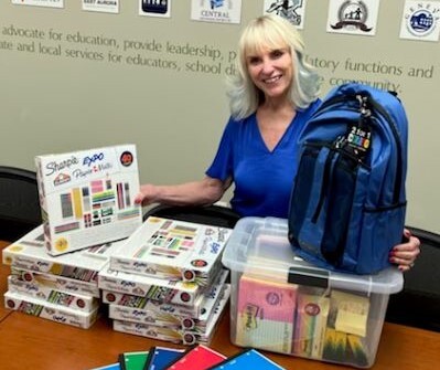 Kane County Regional Superintendent Patricia Dal Santo shows some of the new school supplies that ROE has to help Kane County students have a successful school experience.  Photo credit:  Kane County ROE 