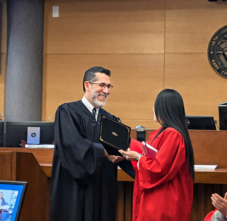 Kane County Judge Rene Cruz congratulates one of three recent graduates of Kane County’s DUI Treatment Court during a ceremony at the courthouse.